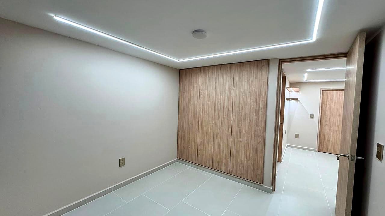Habitación con closet de madera y tira LED en cielo